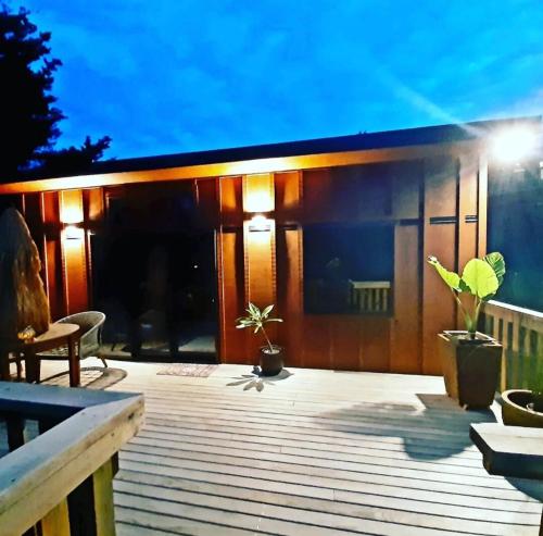 a deck with a house with lights on it at Peace Of Bali in Waihi Beach