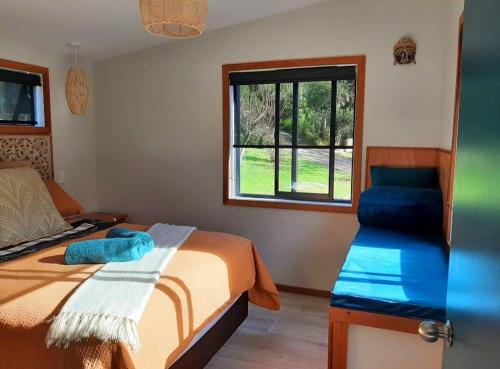 a bedroom with a bed and a window at Peace Of Bali in Waihi Beach
