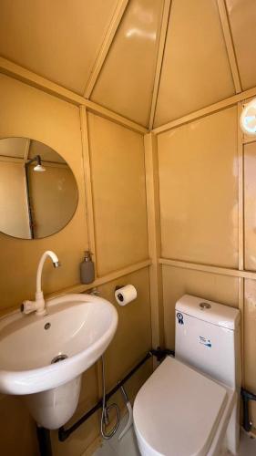 a small bathroom with a sink and a toilet at Dome private camp 1 in Al Raka