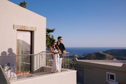 a man and woman standing on the balcony of a building at Mirthea Suites in Mírthios