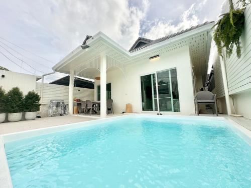 a swimming pool in front of a house at Fiesta Villa Samui in Koh Samui 
