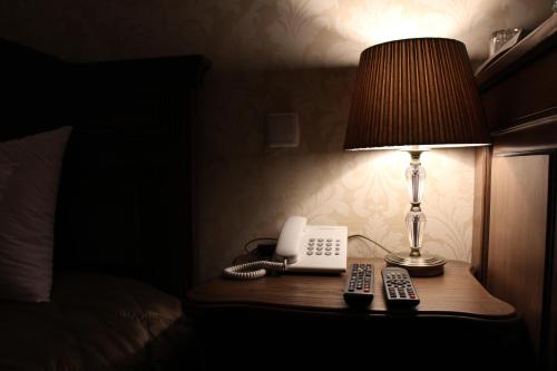 a lamp and a phone on a table in a hotel room at Aristokrat in Vinnytsya