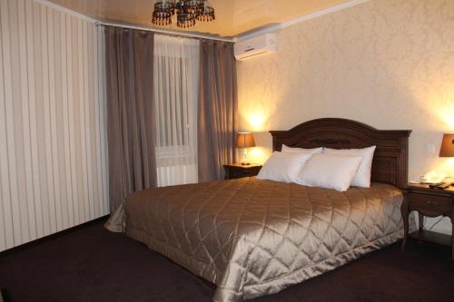 a hotel room with a bed and two tables and a window at Aristokrat in Vinnytsya