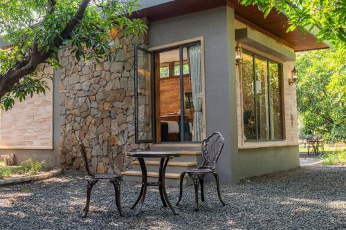 a table and two chairs in front of a house at Mahavan Resort in Chitrod