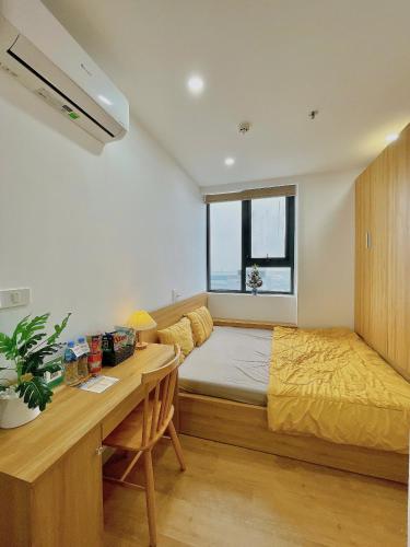 a bedroom with a bed and a desk in it at Amy Apartment in Nera Garden Hue in Thôn Văn Dương