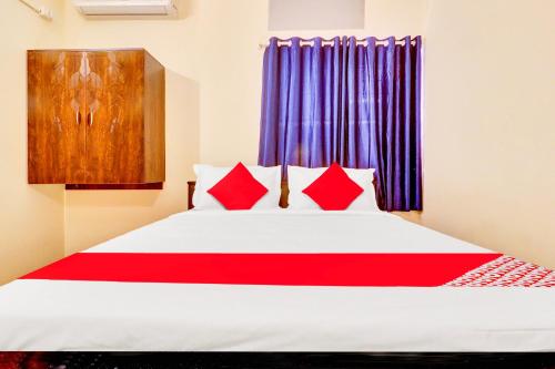 a bedroom with a large bed with red pillows at Hotel O IRA Comforts in Bengaluru