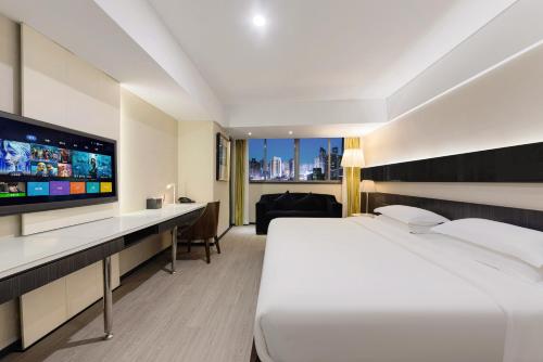 a hotel room with a bed and a flat screen tv at 重庆江北观音桥高悦酒店地铁站店KaoYu Hotel in Chongqing