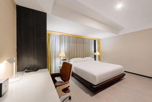 a bedroom with a bed and a desk with a chair at 重庆江北观音桥高悦酒店地铁站店KaoYu Hotel in Chongqing