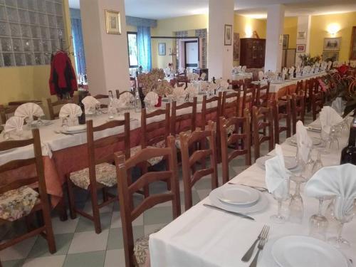 a large dining room with white tables and wooden chairs at Hotel Ebe in San Piero a Sieve