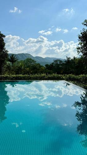 a swimming pool with a view of the mountains at Golden Fields Resort in Mulshi