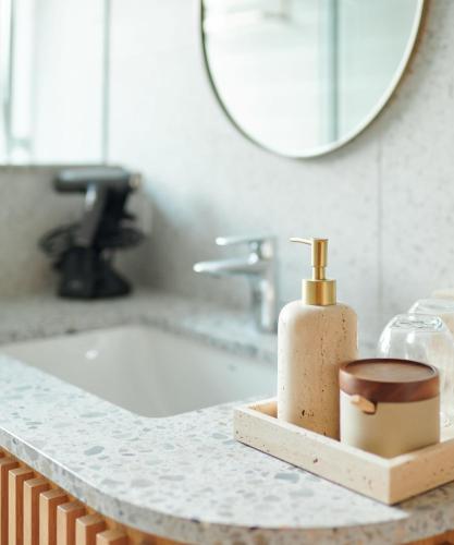 a bathroom sink with a soap dispenser and a mirror at Walk in House in Yuanshan