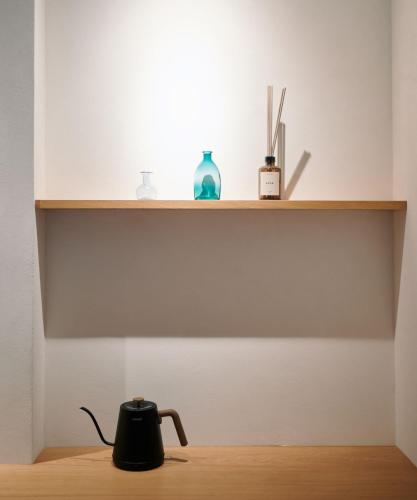 a tea kettle sitting on a wooden floor under a shelf at Walk in House in Yuanshan