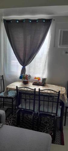 a room with two chairs and a table with a window at Family room Casa Mia at SMDC Styles Residence Tower A in Iloilo City