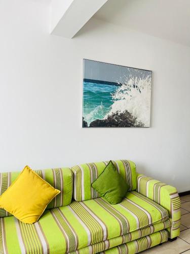 un sofá verde en una habitación con una pintura en la pared en Frere Hill Guesthouse, en Durban