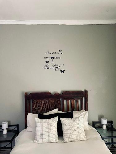 a bedroom with a bed with birds on the wall at Safari Park Guest Farm in Colesberg