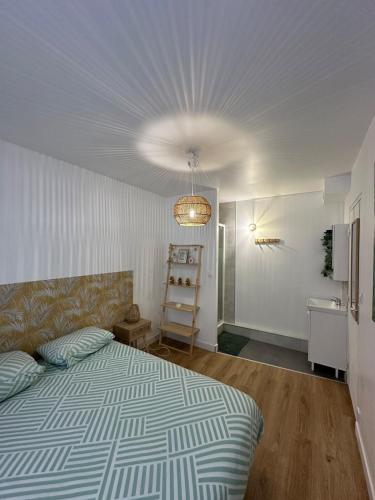 une chambre avec un lit et un lustre dans l'établissement Comme à la maison, à Saint-Brieuc
