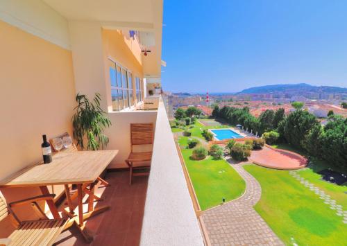 a balcony with a table and a view of a pool at Luxury Condo in Setúbal in Setúbal