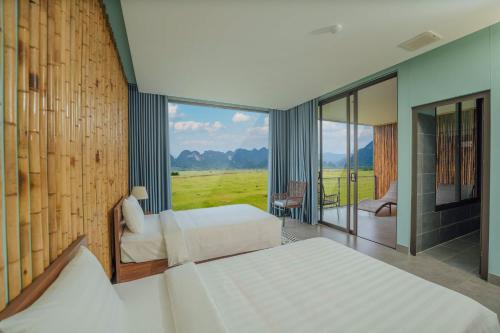 a bedroom with two beds and a large window at Tu Lan Lodge in An Thọ Thôn