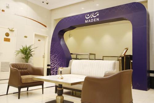 a waiting room with a table and chairs at MADEN Al Rawda مادن الروضة in Al Madinah