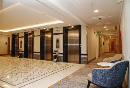 a lobby with chairs and elevators in a building at MADEN Al Rawda مادن الروضة in Al Madinah