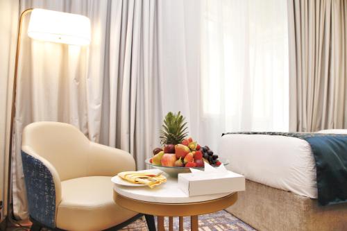 a room with a bed and a table with a bowl of fruit at MADEN Al Rawda مادن الروضة in Al Madinah