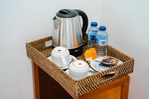a wicker basket with a tea kettle and water bottles at Sundi Villa Penida by ABM in Nusa Penida