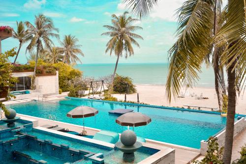 an infinity pool with a view of the beach at Dhevan Dara Beach Villa Kuiburi in Kui Buri