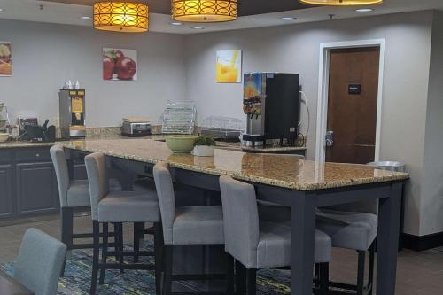 a kitchen with a bar with chairs and a coffee maker at Quality Inn Danville - University Area in Danville