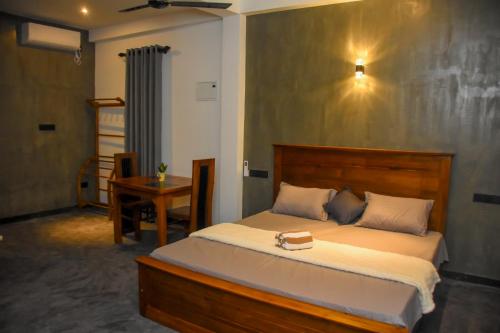 a bedroom with a large bed and a desk at Black Pearl Apartments - with free snorkeling Mirissa in Mirissa
