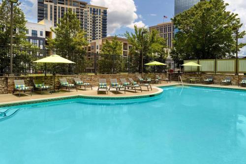 a large swimming pool with chairs and umbrellas at Wyndham Atlanta Buckhead Hotel & Conference Center in Atlanta