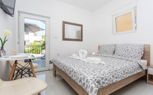 a bedroom with a bed and a table and a balcony at Apartments Bernardeta 1 in Baška