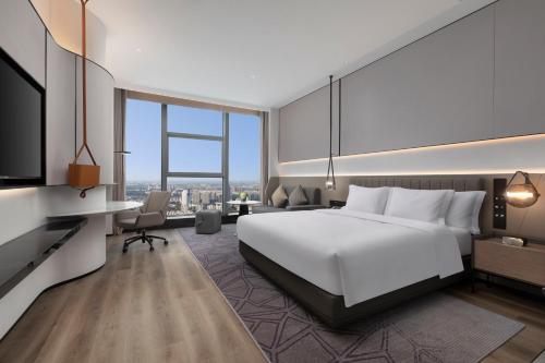a hotel room with a bed and a tv at Crowne Plaza Taizhou City Center by IHG in Taizhou
