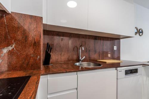 a kitchen with white cabinets and a sink at Papa Pius in Sabadell