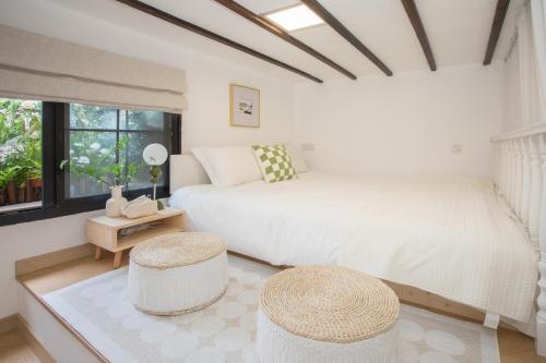 a bedroom with a bed and two stools at Tonight Homestay Jing'an Temple Branch Shanghai in Shanghai