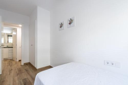 a white room with a bed and a kitchen at Papa Pius in Sabadell