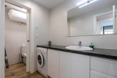 a bathroom with a sink and a washing machine at Papa Pius in Sabadell