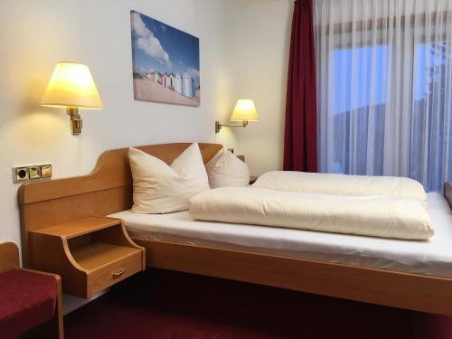 a bed in a hotel room with a window at Hotel & Restaurant Druidenstein in Trautenstein