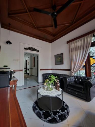 a living room with a black couch and a table at Domore Lifestyle in Jetis