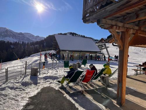a group of people sitting in chairs on a ski slope at Champoussin A'part in Champoussin