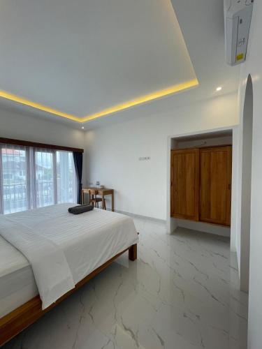 a bedroom with a large bed and a large window at Palm&Ocean Canggu in Canggu