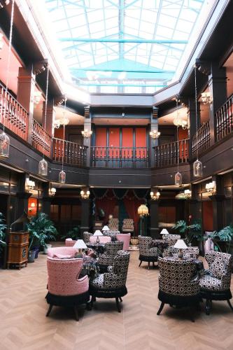 a lobby with tables and chairs in a building at Beijing Xiaofengxian Former Residence Hotel Tiananmen Square Qianmen Store in Beijing