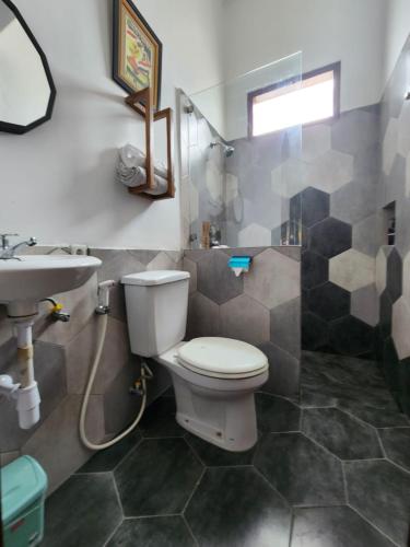 a bathroom with a toilet and a sink at Domore Lifestyle in Jetis