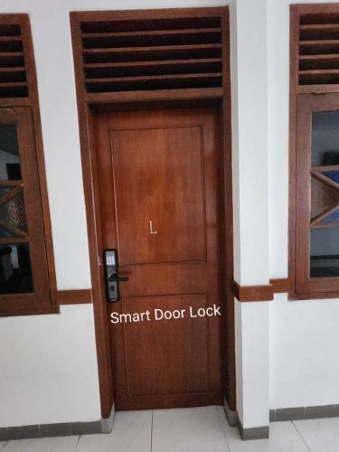 a wooden door with the words smart door lock on it at Domore Lifestyle in Jetis