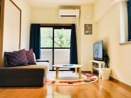a living room with a couch and a table at 三の丸Stay in Kumamoto