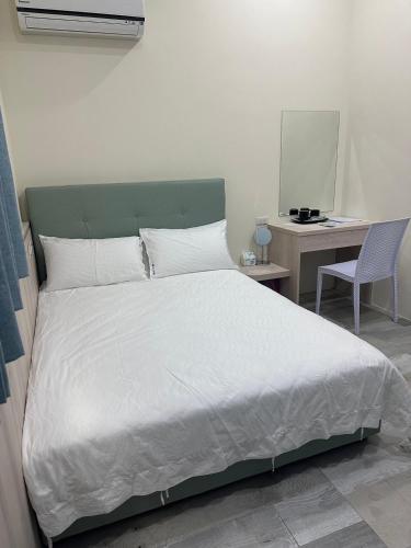 a bedroom with a bed and a desk with a computer at One third of an acre B&B in Magong