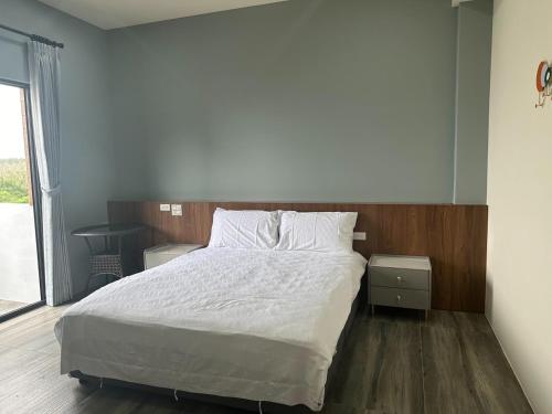 a bedroom with a bed and a large window at One third of an acre B&B in Magong