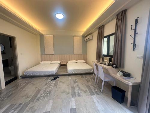 a room with two beds and a table and a desk at One third of an acre B&B in Magong