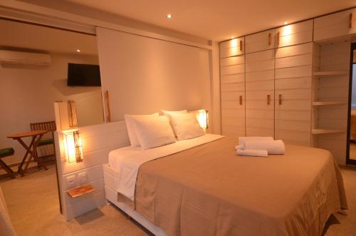 a bedroom with a large white bed with towels on it at Arca do Noah in Jericoacoara