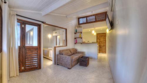 a living room with a chair and a kitchen at Arca do Noah in Jericoacoara