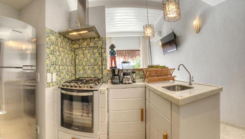 a kitchen with a stove and a sink at Arca do Noah in Jericoacoara
